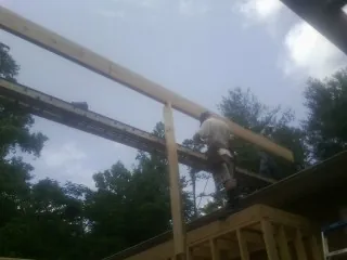 Carpenter setting a ridge beam over a new addition frame — Ice Dam Removal by Roofing Brothers in Argyle