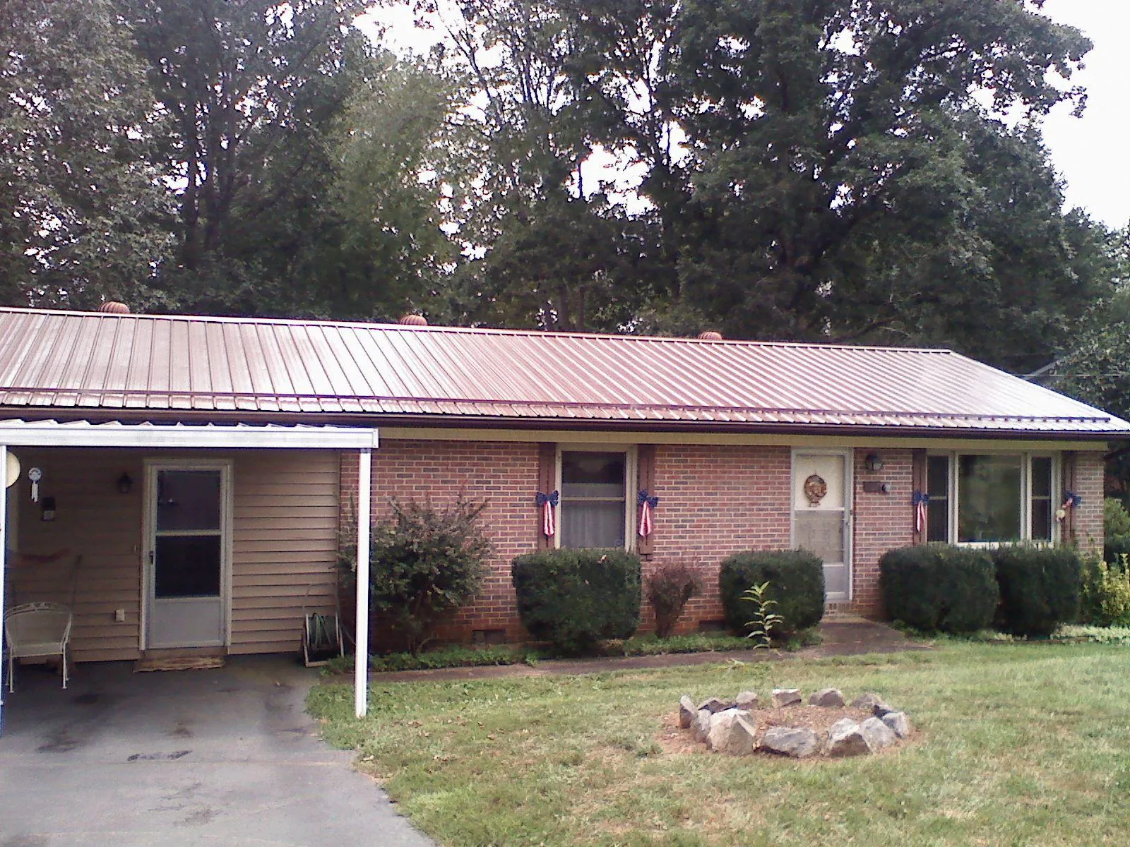 Bronze metal roof and carport on a brick ranch home — Roof Repair work by our crew in Argyle